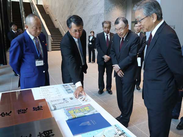 定礎箱に納める品を確認する（左から）井戸、大島社長、竹中工務店の竹中統一名誉会長、佐々木正人社長